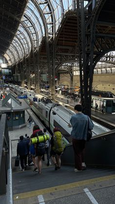 several people are waiting at the train station for their trains to arrive and go on