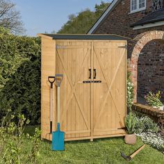 a garden shed with gardening tools in the grass