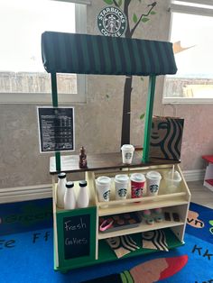 a starbucks coffee stand with cups on it