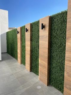 a row of wooden privacy panels next to a white building