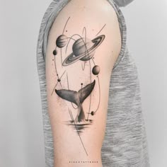 a person with a tattoo on their arm and some planets around them in black ink