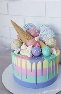 a colorful cake with ice cream, candy and candies on the top is decorated in pastel colors