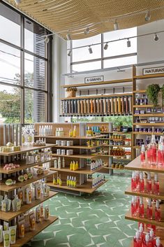 a store filled with lots of different types of bottles and containers on shelves next to large windows