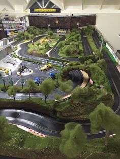 a model train set is shown in the middle of a track with cars and trucks on it