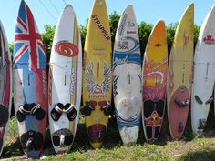 many surfboards are lined up next to each other