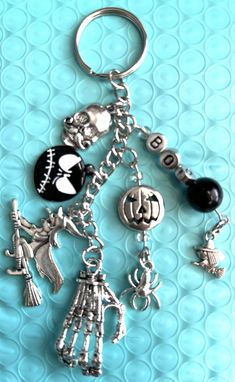 a keychain with charms attached to it on a blue background, including a skeleton and other items