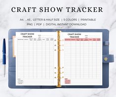 the craft show tracker book is open on top of a marble table with a pen