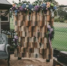 a chair sitting in front of a wooden structure with flowers on it's sides