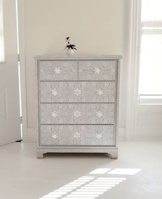 a white dresser sitting in the corner of a room