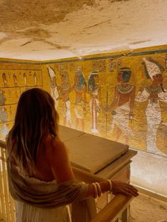 a woman standing in front of a wall painting