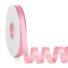 a roll of pink satin ribbon next to it