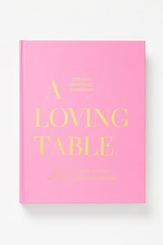 a pink book with gold lettering that reads, a loving table written in cursive writing