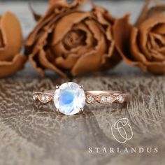 a close up of a ring on a table with roses