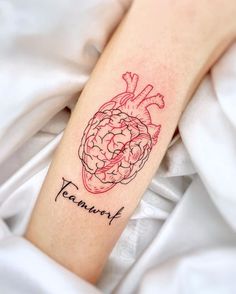 a tattoo on the arm of a person with a heart and brain in red ink