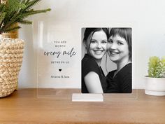 a couple of pictures sitting on top of a wooden table next to a potted plant