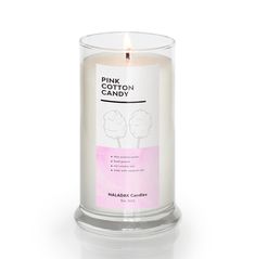 a white candle with pink cotton candy in it's glass holder on a white background