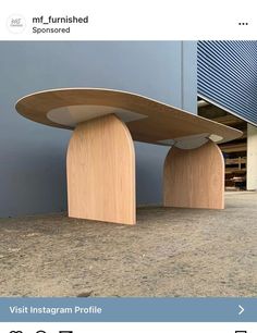 two wooden benches sitting next to each other on the ground in front of a building