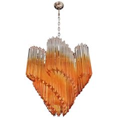 an orange chandelier hanging from a chain on a white background in the style of murano