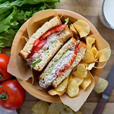 a close up of a plate of food with chips and vegetables on the table next to it