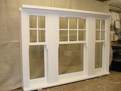 an unfinished room with white windows and wood flooring