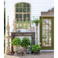 a house with potted plants in front of it and an open door to the outside