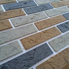 a brick wall with different colored bricks on the top and bottom half, along with a wooden floor