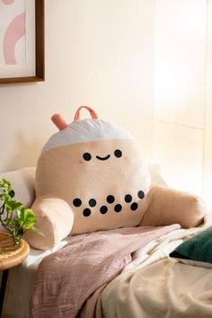 a large stuffed animal sitting on top of a bed next to a potted plant