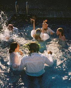 several people are in the water with their arms up