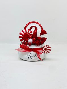 a red and white hat with candy canes on it's side, sitting in a box