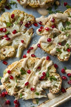 roasted cauliflower with pomegranate and white sauce on a baking sheet