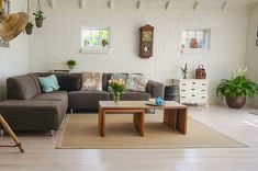 a living room with white brick walls and wood flooring is furnished with modern furniture