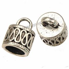 two silver toned metal beads with an openwork design on each side and a hole in the middle