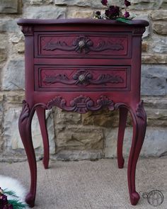 a red painted dresser with flowers on top