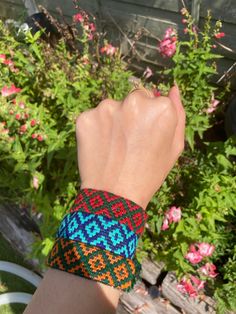 a woman's hand wearing a colorful bracelet