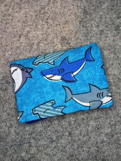 "The Pocket Wallet is a perfect little wallet when you don't want to carry much!  It has a zipper pocket for coins and two pockets for folded paper money and/or credit cards. It stays secure with a magnetic snap. The Pocket Wallet pattern was designed by Sid's In Stitches. The exterior of this wallet has different sharks on a blue background.  The interior and zipper are in coordinating blue colors. I was looking for a small wallet to fit inside the Itsi purse and this Pocket Wallet ended up being perfect.  I love how it shows off the complimenting fabrics and has a little zipper pocket.  The magnetic snap closure holds the two sides together.  Wallet Size: Closed: 4\" x 3\" x 0.5\" Opened: 4\" x 6\" Details: -Zipper Pocket -Magnetic Closure -Two Interior Pockets" Blue Pouch Wallet As Gift, Blue Zipper Coin Purse As Gift, Blue Pouch Wallet For Gift, Cheap Blue Trifold Wallet With Coin Pocket, Cute Blue Wallets For Gift, Cute Blue Wallets For Gifts, Blue Pouch Wallet For Personal Use, Blue Rectangular Coin Purse With Cell Phone Pocket, Blue Coin Purse With Card Slots For Personal Use