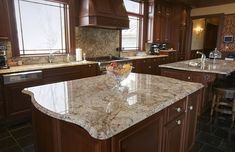 a kitchen with marble counter tops and wooden cabinets