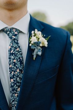 groom in his wedding day attire in a navy suit with floral tie Groom Getting Ready Photos, Neutral Wedding Decor, Navy Groom, Navy Suit Wedding, Grooms Party