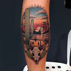 a man's leg with a cactus and deer skull tattoo on it