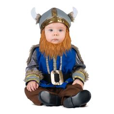 a baby dressed as a viking sitting on the floor