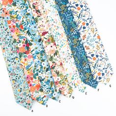 four ties are lined up in different colors and patterns, one has flowers on it