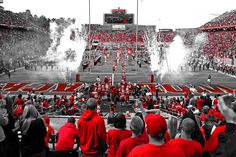 a football stadium filled with lots of red and white people standing on the sidelines