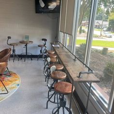 a row of stools sitting in front of a window next to a counter top