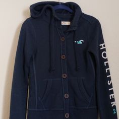 Navy Hollister, Button-Up Hoodie. "Hollister 22" On Left Sleeve. Good Condition, No Rips Or Stains. Casual Hooded Top With Button Closure, Casual Cotton Hoodie With Button Closure, Long Sleeve Hoodie With Button Closure For Fall, Streetwear Hooded Jacket With Button Closure, Fall Long Sleeve Hoodie With Button Closure, Cotton Hoodie With Buttons For Fall, Casual Hooded Jacket With Button Closure, Casual Long Sleeve Hooded Jacket With Button Closure, Cotton Hoodie With Buttons