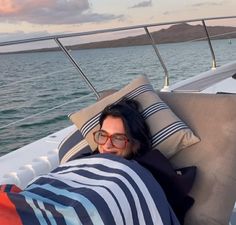 a woman laying on the back of a boat