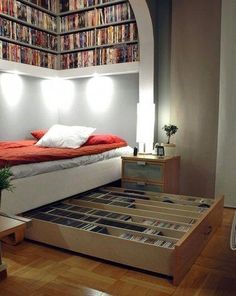 a bed sitting in the middle of a room filled with books