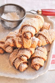 powdered sugar filled pastries on a white plate