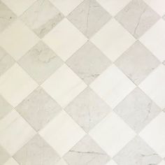 a tiled floor with white and grey tiles on it's sides, in an area that looks like a diamond pattern