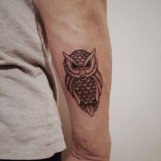 an owl tattoo on the left arm