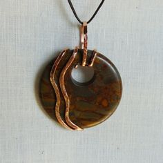 a brown and black pendant on a white background