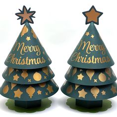 two green christmas trees with gold stars and merry lettering on them, sitting side by side